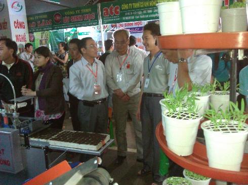 Anh Hồng Chương (bên phải) giới thiệu máy gieo hạt chân không tại một hội chợ